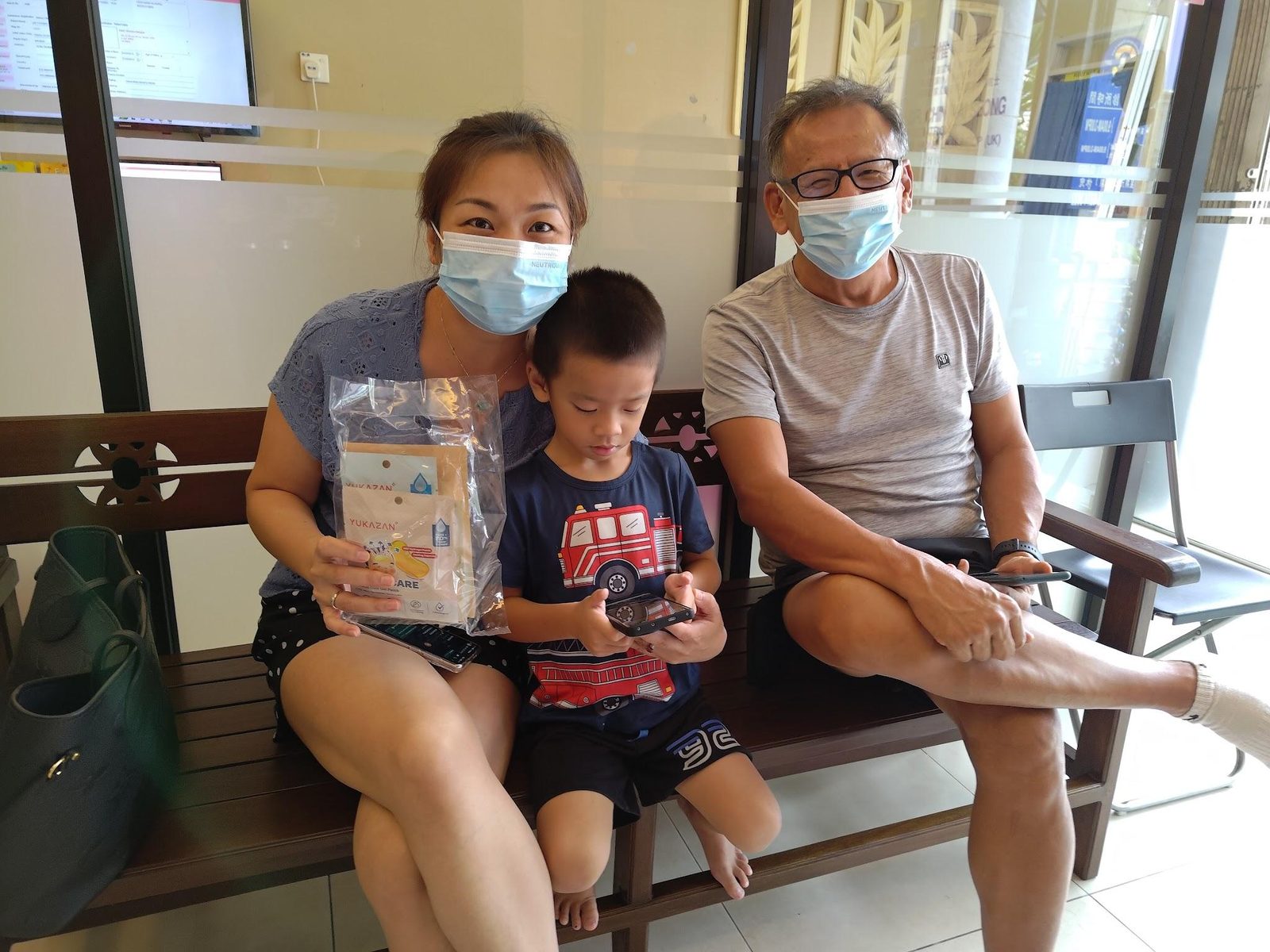 A family with a young child receives a Nurture Circle sample pack in a clinic waiting area