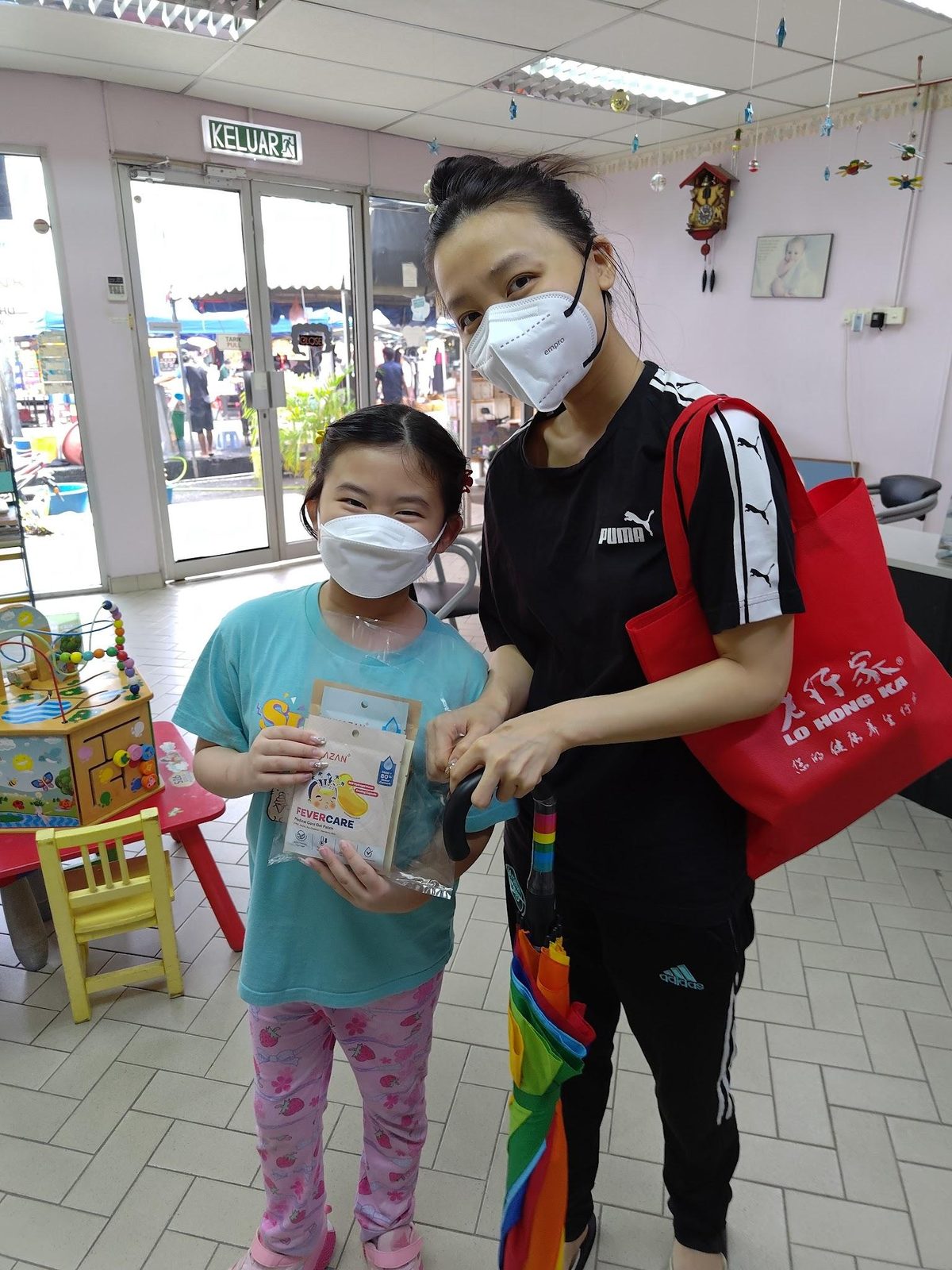 A mother and child take part in a Nurture Circle product sampling activity outside a clinic