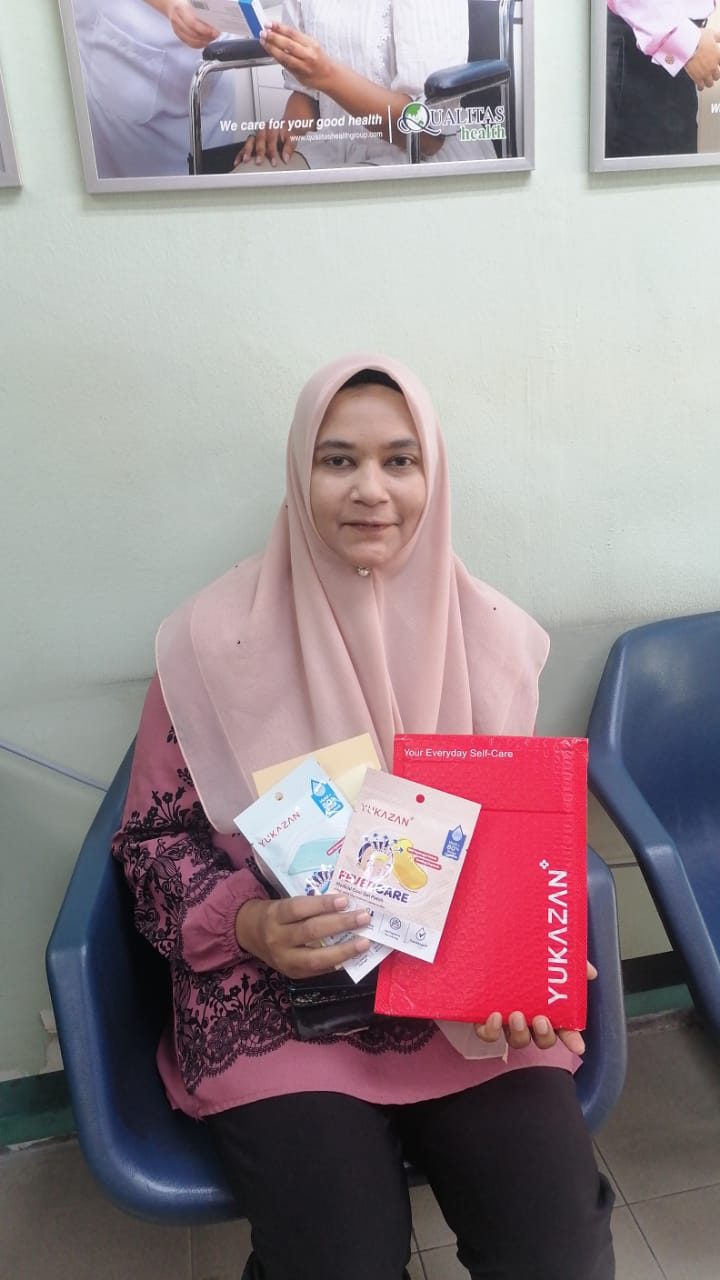 A seated participant holds Nurture Circle goodie bag contents at a clinic