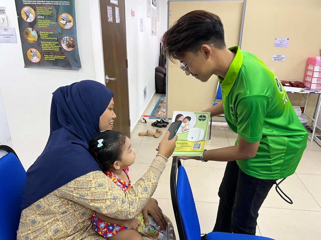An Avante programme facilitator demonstrates a product to a mother and toddler during a clinic activation